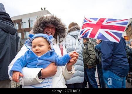 Edimburgo, Scozia, Regno Unito. 2 ottobre 2021. NELLA FOTO: Un bambino tiene la bandiera Union Jack con la mamma mentre i cecchini si trovano sul tetto dietro il Parlamento scozzese. Sua Maestà la Regina apre ufficialmente il Parlamento Scozzese con una pesante presenza di polizia, con numerose forze di sicurezza e l'esercito britannico in piedi guardia. Le strade erano fiancheggiate da buoni wishers alcuni hanno visto onditare le bandiere di Union Jack e la gente che scattava le foto sui loro telefoni della macchina fotografica. Charles e Camilla partirono poi dall'elicottero reale. Credit: Colin Fisher/Alamy Live News Foto Stock