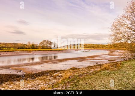 Mudflats con neve e gelo a terra, sull'estuario del fiume Dee a Kirkcudbright al tramonto in inverno, Dumfries e Galloway, Scozia Foto Stock