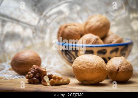Sfondo alimentare. Nocciole tritate di noce e noci intere giacciono su un tavolo di legno. Foto Stock