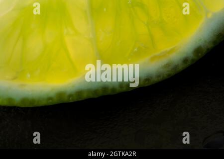 Macro frutta: Taglio lime maturo da primo piano con fondo nero, formato orizzontale Foto Stock