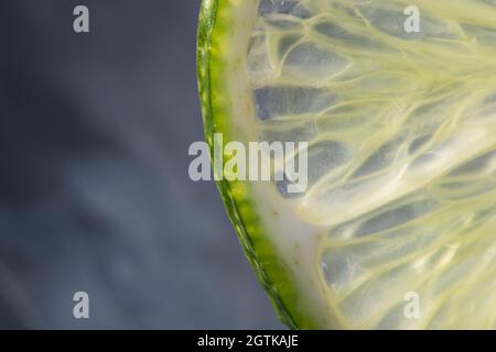 Macro frutta: Taglio lime maturo da primo piano con fondo nero, formato orizzontale Foto Stock
