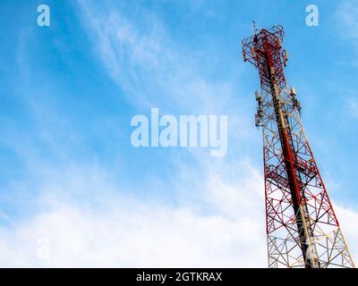 Torre di comunicazione dalla vista inferiore con sfondo cielo blu. Foto Stock