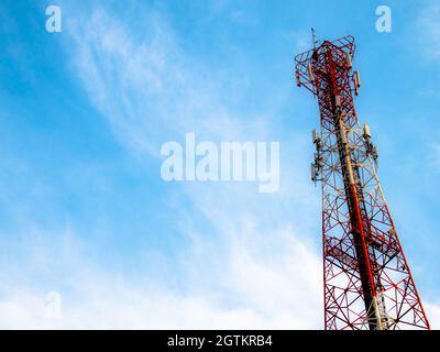 Torre di comunicazione dalla vista inferiore con sfondo cielo blu. Foto Stock