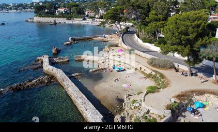 Vista aerea di un muro crollato tra Ondes Beach e Mallet Beach sul Cap d'Antibes in Costa Azzurra - piscina naturale creato dalle rovine di Foto Stock