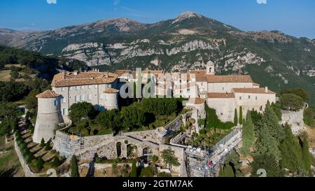 Veduta aerea del borgo medievale di Gourdon in Provenza, Francia - Castello con una torre rotonda costruita sul bordo di una scogliera in montagna Foto Stock