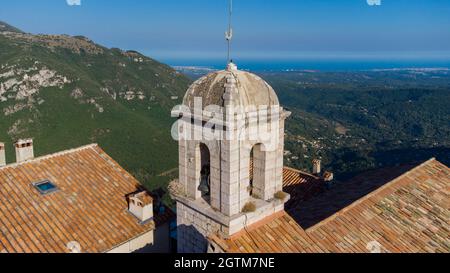 Veduta aerea del campanile della chiesa di Gourdon in Provenza, Francia - borgo medievale costruito sul bordo di una scogliera in montagna Foto Stock