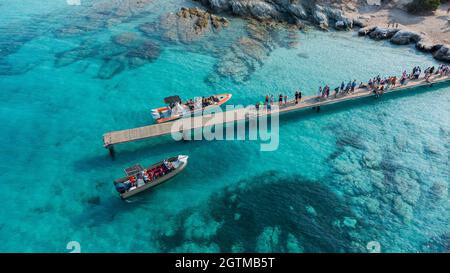 Veduta aerea di motoscafi ormeggiati a un pontone vicino a Loto Beach nel deserto Agriates a nord-ovest di Saint Florent, Corsica, Francia - molo di legno sopra a. Foto Stock