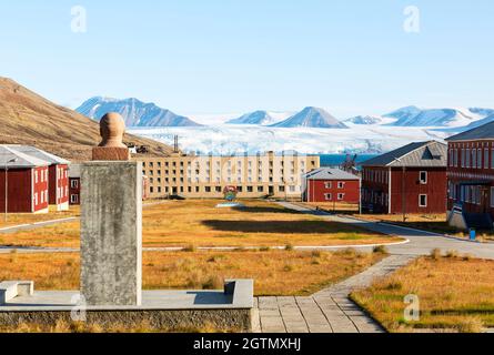 Vista a abbandonato insediamento artico russo con il busto di Lenin in primo piano a Pyramiden, Norvegia. Foto Stock