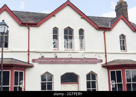 Cartello d'ingresso sulla stazione ferroviaria di Llanfairpwll, Llanfairpwlgwyngyll, Isle of Anglesey (Ynys Mon), Galles, Regno Unito Foto Stock