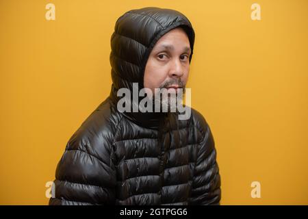 Primo piano di un uomo su sfondo giallo Foto Stock