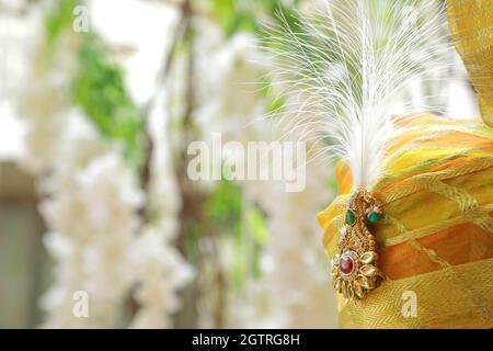 Immagina una scena vivace sotto un mandap splendidamente decorato, dove la coppia felice si siede fianco a fianco, irradiando gioia. La sposa, riccamente adornata Foto Stock