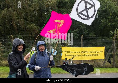 Farnborough, Regno Unito. 2 ottobre 2021. Estinzione gli attivisti climatici della ribellione si trovano fuori da un ingresso all'Aeroporto di Farnborough. Gli attivisti hanno bloccato tre ingressi all'aeroporto privato per evidenziare livelli elevati di anidride carbonica prodotti dai passeggeri super ricchi che utilizzano jet privati e il lavaggio del verde da parte dell'aeroporto, annunciando il passaggio al carburante per aviazione sostenibile (SAF). Credit: Mark Kerrison/Alamy Live News Foto Stock