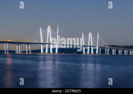 Il Ponte del Governatore Mario M. Cuomo, illuminato da luci bianche, attraversa il fiume Hudson al crepuscolo mattutino. Foto Stock