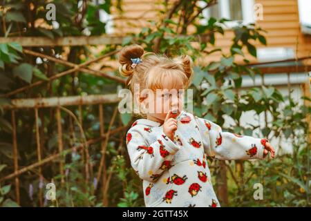 bambino in giardino con frutti di bosco Foto Stock