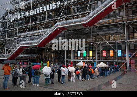Parigi, Francia, 2 ottobre 2021: L'annuale Nuit Blanche a Parigi, quando i musei pubblici rimangono aperti fino a tarda notte e hanno ingresso gratuito, ha ancora attratto una folla di appassionati d'arte al Centre Georges Pompidou nonostante le forti piogge e le condizioni di tempesta. Per gli adulti, l'ingresso a tutti gli spazi pubblici, come musei e ristoranti, richiede un Pass Sanitaire (Health pass) come prova di essere vaccinati per essere mostrato sull'app TousAnticovid. Da giovedì 7 ottobre questo requisito sarà esteso ai bambini dai 12 ai 17 anni. Anna Watson/Alamy Live News Foto Stock