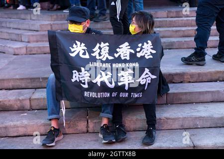 I manifestanti hanno visto tenere la bandiera che dice 'liberate Hong Kong. Rivoluzione dei nostri tempi' durante la dimostrazione. Il 1° ottobre, varie diaspore anti-Cina a Londra si sono riunite in solidarietà contro il Partito comunista cinese. Tenuto congiuntamente da Hong Kong Liberty, World Uyghur Congress, Free Tibet e altri, a Piccadilly Circus sono stati tenuti discorsi per condannare le violazioni dei diritti umani da parte del PCC. I manifestanti in seguito marciarono presso l'Ambasciata cinese a Londra, dove venne bruciata la Bandiera Nazionale Cinese. (Foto di Belinda Jiao/SOPA Images/Sipa USA) Foto Stock