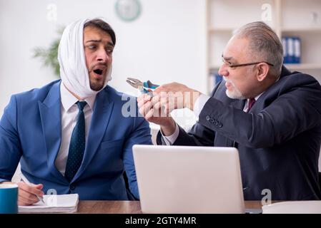 Giovane impiegato d'affari che soffre di mal di denti in ufficio Foto Stock