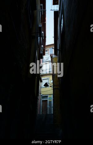 Vicolo scuro tra edifici colorati a Porto, Portogallo. Tipica strada laterale portoghese colorata e tradizionale tra edifici di appartamenti alti. Foto Stock