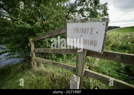 PRIVATO - NESSUN segno DI PESCA su una recinzione vicino ad un fiume / ruscello a Northumberland, Regno Unito. Una recinzione di legno con un cartello che dice 'privato No Fishing'. Foto Stock