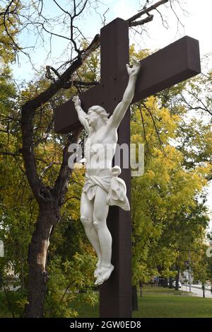 Una statua a grandezza naturale di Gesù sulla croce si erge sul terreno della Cattedrale di San Bonifacio nel quartiere di San Bonifacio a Winnipeg, Manitoba, Foto Stock