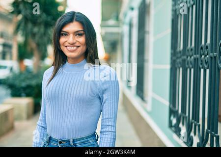 Bella donna ispanica sorridente confidente in città Foto Stock