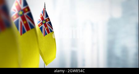 Piccole bandiere di Niue su uno sfondo sfocato della città Foto Stock