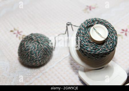Processo di avvolgimento del filo verde di lana da groviglio ad avvolgimento, utilizzando un coiler su tavola Foto Stock