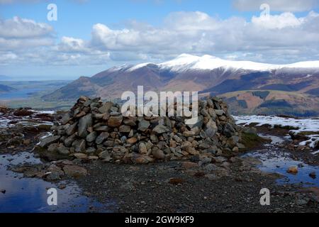 La catena montuosa del 'Skiddaw' nella neve dalla piattaforma di pietra sulla cima di Wainwright 'Bleaberry Fell' nel Lake District National Park Cumbria. Foto Stock