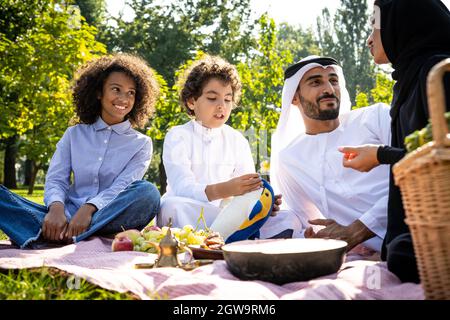 immagine cinematografica di una famiglia degli emirates che trascorre del tempo al parco Foto Stock
