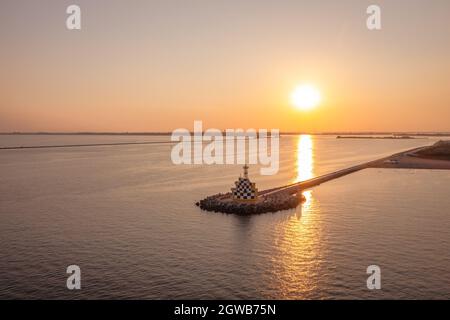 Faro di Punta Sabbioni sulla costa del Mediterraneo Adriatico in Italia. Vista aerea sulla spiaggia durante le vacanze estive. Foto Stock