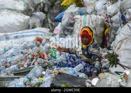 Palu, Sulawesi Centrale, Indonesia. 3 ottobre 2021. I lavoratori che vanno dai bambini piccoli agli anziani risolvano i rifiuti che possono ancora essere riutilizzati nelle discariche del villaggio di kawatuna, Palu City, Sulawesi Centrale. (Credit Image: © Adi PranataZUMA Wire) Credit: ZUMA Press, Inc./Alamy Live News Foto Stock