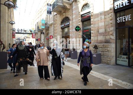 Donne palestinesi, amanti dello shopping, indossare maschere per il viso a causa di Corona, passeggiare nel quasi vuoto Mamilla Mall o Alrov Mamilla Avenue vicino alla città vecchia di Gerusalemme. Foto Stock