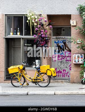 L'esterno della cantina Weinen e la bicicletta Deutsche post gialla parcheggiata all'esterno, Brunnenstrasse 6, Mitte, Berlino, Germania Foto Stock