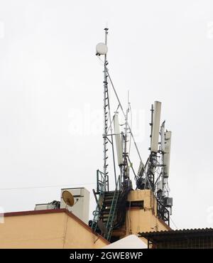 Antenna parabolica per la ricezione del segnale satellitare mobile installata sulla parte superiore di un edificio sul tetto Foto Stock