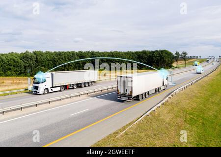 Comunicazione tra veicolo e veicolo. Scambio di dati tra i carrelli in autostrada. Foto Stock