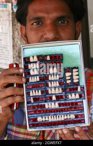 Il dentista di strada del Bangladesh mostra i suoi denti di sostituzione in una strada della vecchia Dhaka il 24 ottobre 2013.trattamento dentale a costoso che la gente povera Foto Stock