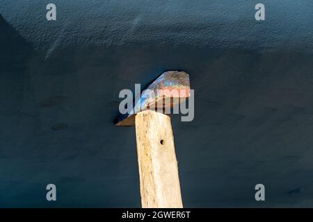 cuneo di legno sotto la chiatta di barche di yacht in bacino asciutto Foto Stock