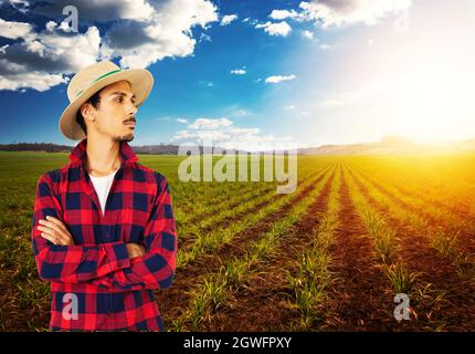 Coltivatore con cappello di fronte alla piantagione di grano fattoria. Foto Stock