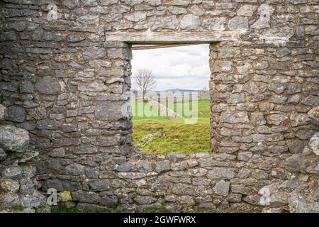 Finestra in rovina di pietra calcarea del 19 ° secolo che mostra il paesaggio e la campagna del Peak District Foto Stock