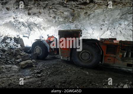 La macchina di carico Uderground picchia pietre nella benna dalla faccia. Foto Stock