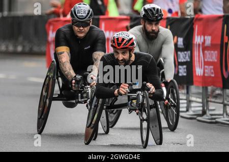 Londra, Regno Unito. 03 ottobre 2021. David Weir, atleta britannico in carrozzella che alla fine ha concluso terzo nella gara (a sinistra), insegue il vincitore del 2020 Brent Lakatos al Mile 19 a Canary Wharf. Dopo un'assenza di 2 anni, la Maratona di Londra Virgin Money torna al suo corso tradizionale da Blackheath al Mall. Si tratta della maratona più grande mai messa in scena, con oltre 40,000 partecipanti, e un numero simile che completa la maratona virtuale su un percorso a loro scelta simultaneamente. Credit: Imagplotter/Alamy Live News Foto Stock