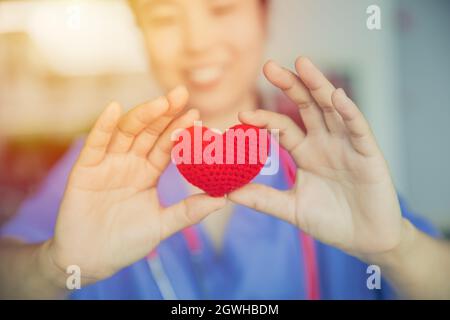 nurse sharing amore rosso cuore per assistenza sanitaria dando aiuto medico e donazione insieme concetto Foto Stock