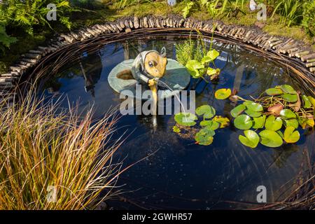 Ornamento da giardino: Scultura di Robert James Workshop di Jeremy Fisher rana pesca in uno stagno al RHS Chelsea Flower Show, Londra SW3 nel settembre 2021 Foto Stock