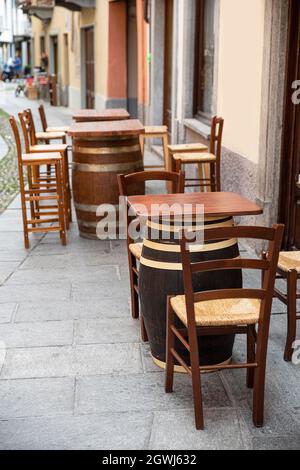 Tavoli da bar e sedie su una terrazza in strada in Italia Foto Stock