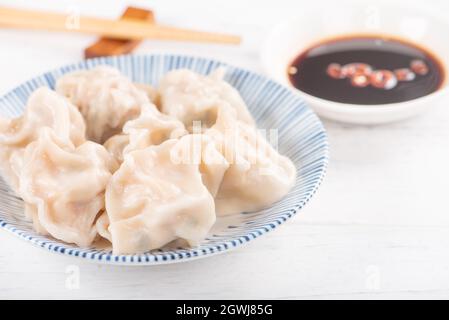 Maiale bollito fresco e delizioso, gnocchi di gyoza Shrimp su sfondo bianco con salsa e chopsticks
