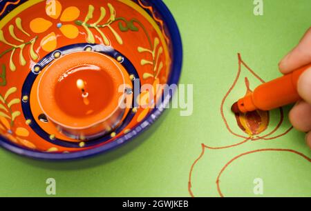 Disegno a mano di un rangoli Diwali su carta con una lampada a candela Diwali. Foto Stock