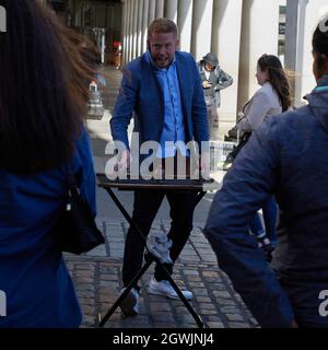 Il mago busker inertaing la folla a Covent Garden UK. Foto Stock