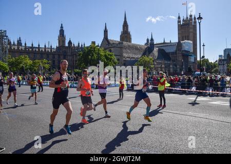 Londra, Regno Unito. 3 ottobre 2021. I corridori passano attraverso Parliament Square durante la Maratona di Londra del 2021. Foto Stock
