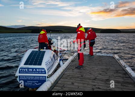 Gli uomini lanciano la barca a remi sull'oceano nella riserva Whiteadder per una sessione di allenamento per la sfida atlantica, East Lothian, Scozia, Regno Unito Foto Stock