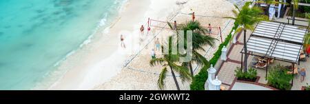 I turisti che giocano a pallavolo sulla spiaggia in hotel di lusso a Cancun, Messico. Foto Stock